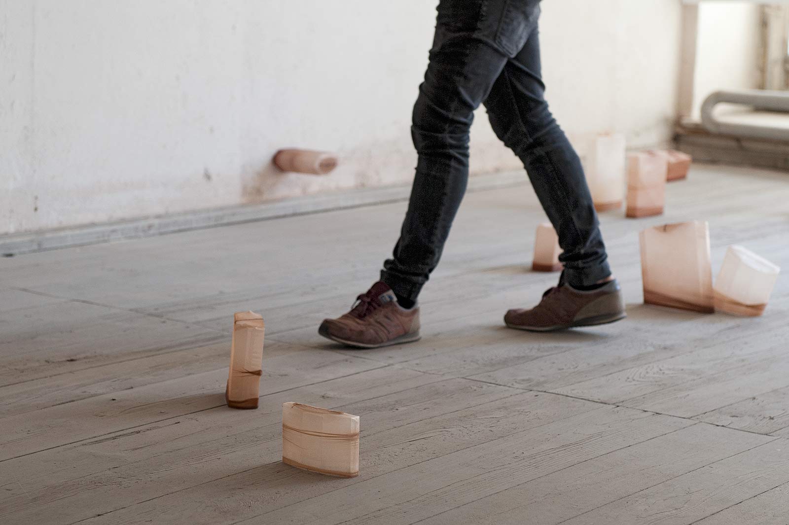 A person walks between the objects of the object installation "shaped bodies".