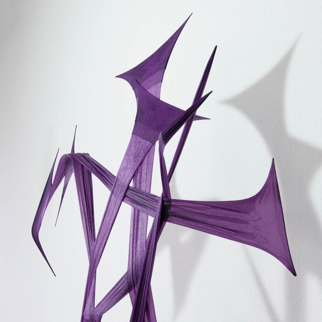 Detail view of an art object made from stretched and cut purple stockings and cured epoxy resin